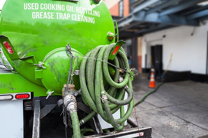 worker pumping grease trap at commercial kitchen in Cape Coral